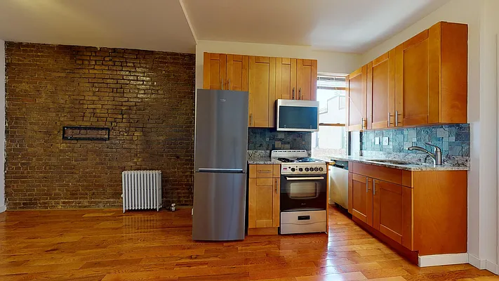 Kitchen and exposed-brick living area at 301 East 76th Street, Apt. 16